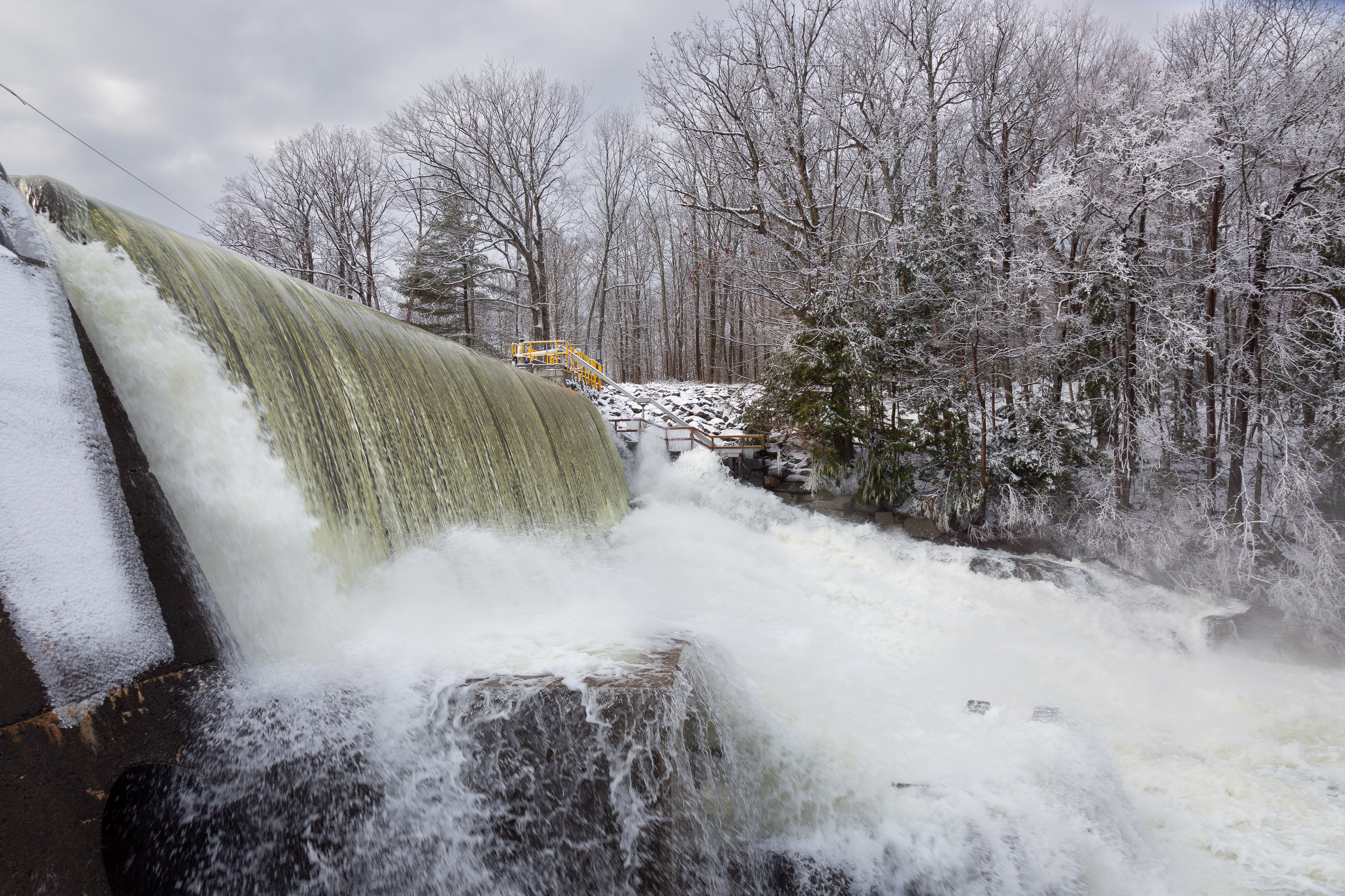 Powerful waterfall flows creating a spray of river water