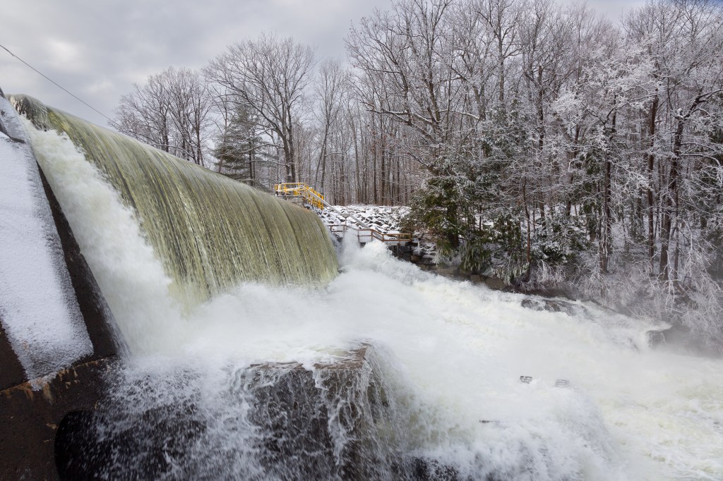 Powerful waterfall flows creating a spray of river water